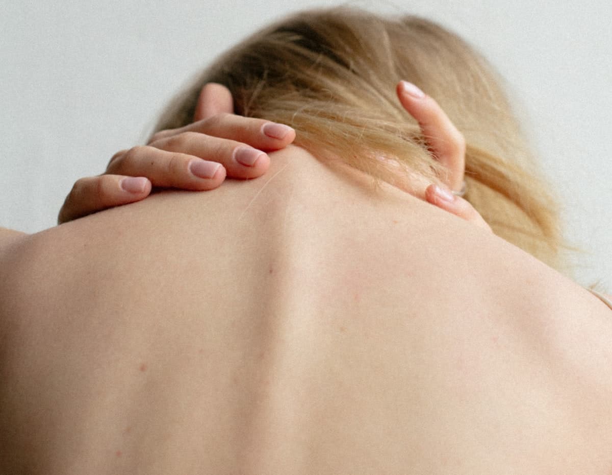 Hands easing tension in someone's neck and shoulders