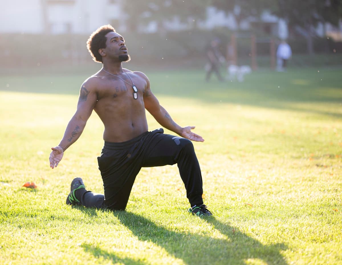 An athlete stretching outdoors in golden light